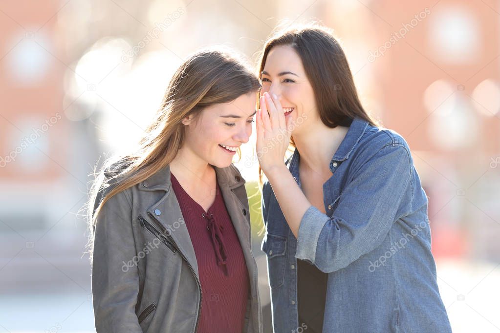 Gossip woman telling secret to her friend