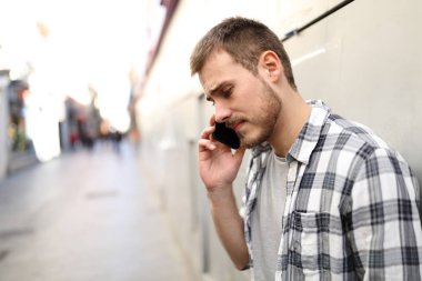Yalnız bir sokakta telefonda üzgün adam konuşuyor