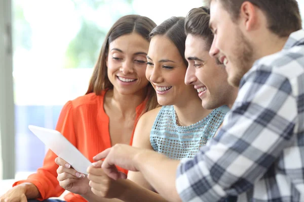 Grupo feliz de amigos verificando tablet em casa — Fotografia de Stock