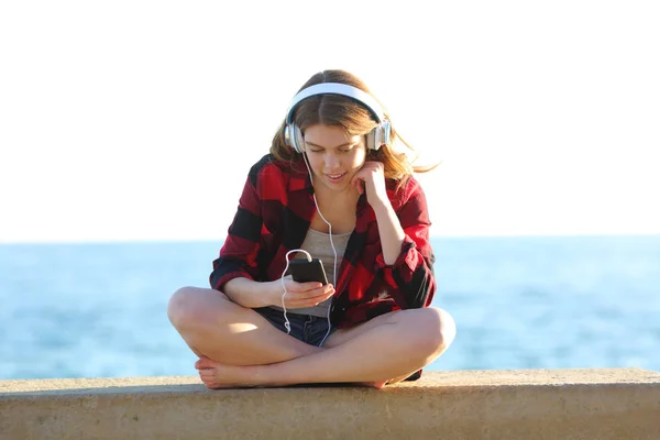 Relaxed teen is listening to music on the beach — Stock Photo, Image