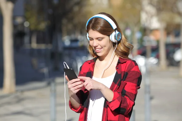 屋外を歩く音楽を聴いて幸せな十代の女の子 — ストック写真