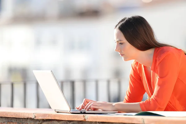 Self employed writing on laptop in a balcony — Stock Photo, Image