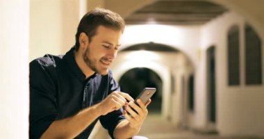 Heyecanlı adam gece sokakta online akıllı telefon içeriği bulma
