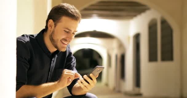 Happy Man Browsing Online Smarphone Content Sitting Street Night — стоковое видео