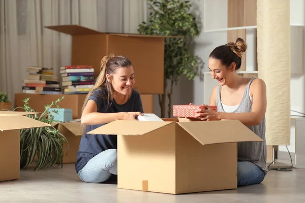 Rommates felizes unboxing pertences que se deslocam para casa — Fotografia de Stock