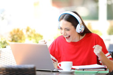 Excited student e-learning in a coffee shop clipart