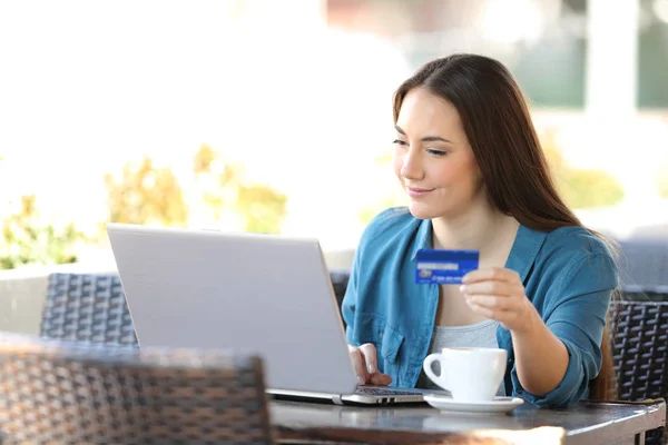 Kvinna betalar online med en bärbar dator och kreditkort i en bar — Stockfoto