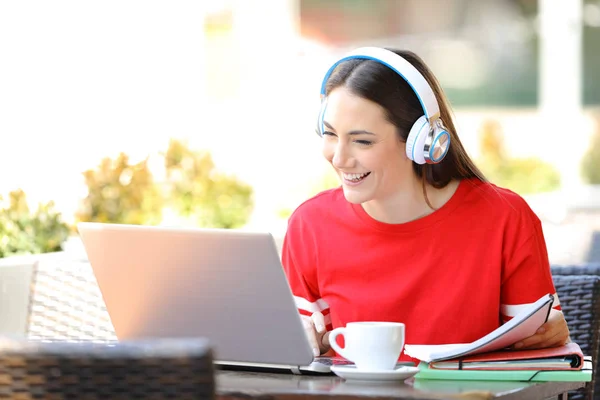 Happy student med hörlurar e-Learning med en bärbar dator — Stockfoto
