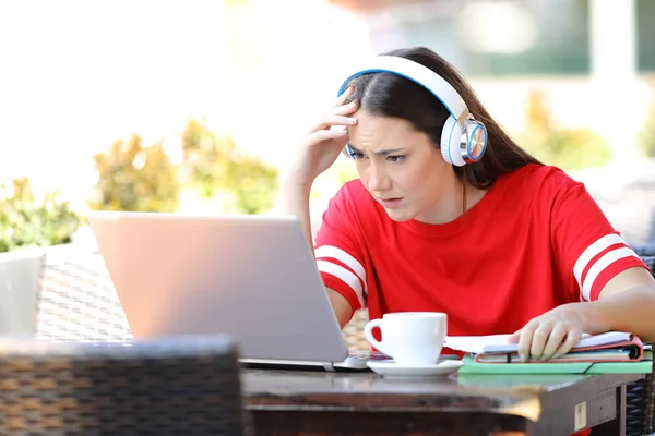 Étudiant inquiet e-learning avec un ordinateur portable dans un café — Photo