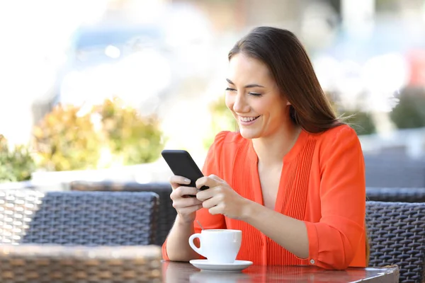 Η χαρούμενη γυναίκα στέλνει μηνύματα στο έξυπνο τηλέφωνο σε μια καφετέρια. — Φωτογραφία Αρχείου