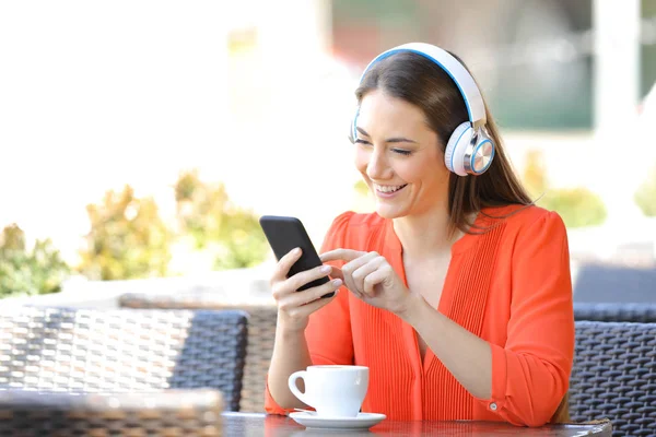 Lycklig kvinna lyssnar på musik på ett kafé — Stockfoto