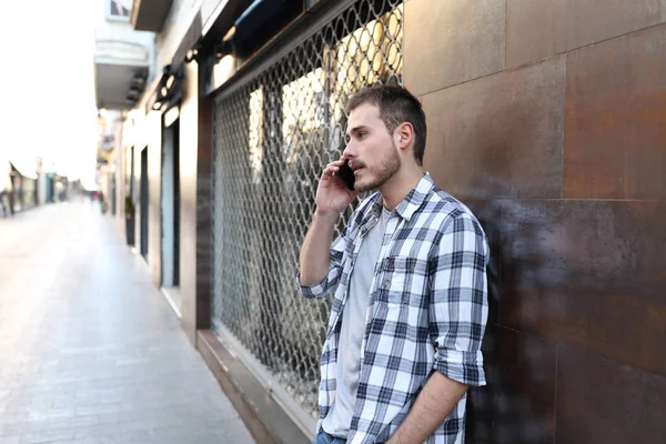 Un hombre serio hablando por teléfono en la sreet de un casco antiguo — Foto de Stock