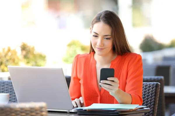 Entreprenör kontrollera telefon som arbetar i ett kafé — Stockfoto