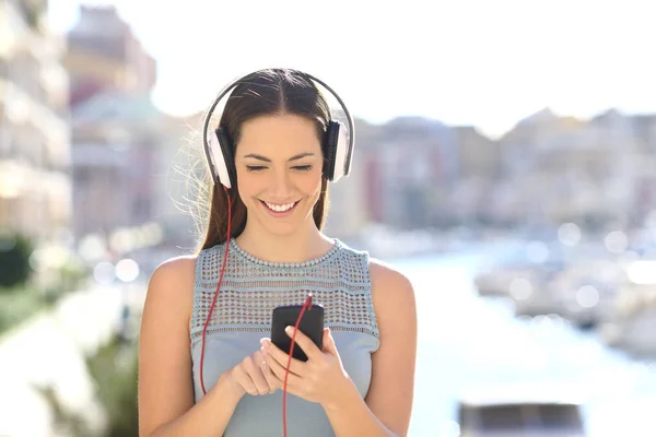 Vista frontal de uma menina ouvindo música escolhendo músicas — Fotografia de Stock