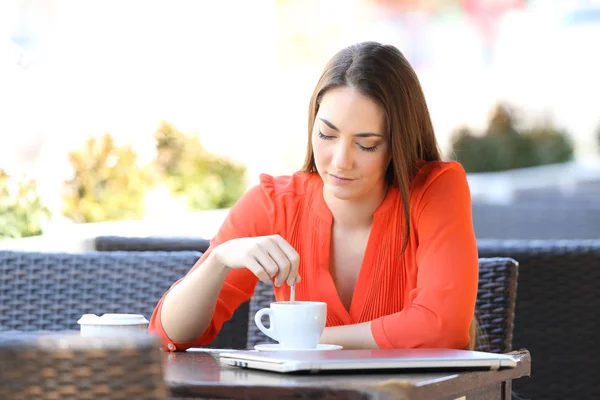 Mujer seria en una cafetería revolviendo la bebida —  Fotos de Stock