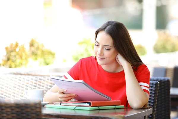 Student het lezen van notities in een bar terras — Stockfoto