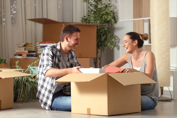 Casal feliz rindo unboxing pertences movendo casa — Fotografia de Stock