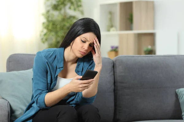 Aggódó nő ellenőrzi okostelefon tartalmat otthon — Stock Fotó