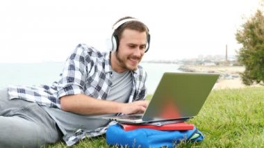 Mutlu öğrenci e-bir dizüstü bilgisayar ile öğrenme ve bir süre açık havada sonra kamera bakarak