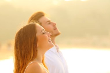 Gün batımında temiz hava soluyarak sahilde mutlu çift