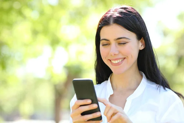 Mujer de belleza feliz usando el teléfono en un parque — Foto de Stock