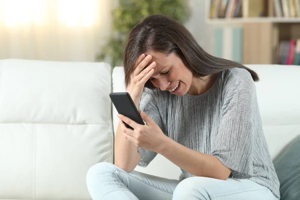 Verdrietig vrouw thuis controleren van de smartphone — Stockfoto