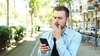 Sokakta karar vermeye çalışan akıllı telefon kullanarak şüpheli adam