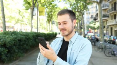 Heyecanlı adam akıllı telefon kullanır ve inanılmaz içerik bulur. Sonra kameraya bakar