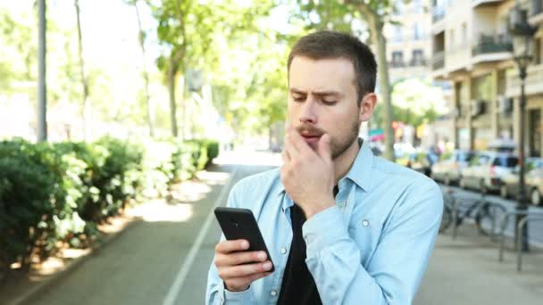 Twijfelachtige Man Met Behulp Van Smart Phone Proberen Beslissen Straat — Stockvideo