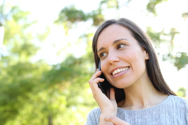 Mulher feliz fala ao telefone em um parque — Fotografia de Stock