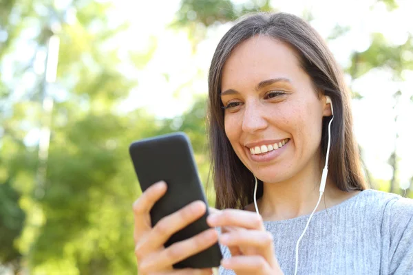 Mulher adulta engraçada ouvindo música verificando conteúdo no telefone — Fotografia de Stock