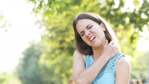 一个女人在公园里浑身瘙痒 扭伤了脖子 — 图库视频影像