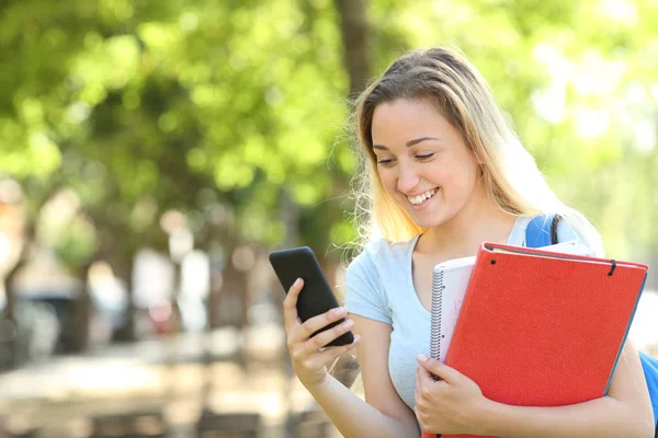 Glückliche Studentin im Park mit Smartphone — Stockfoto