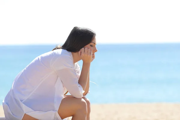 Profil d'une femme inquiète assise sur la plage — Photo