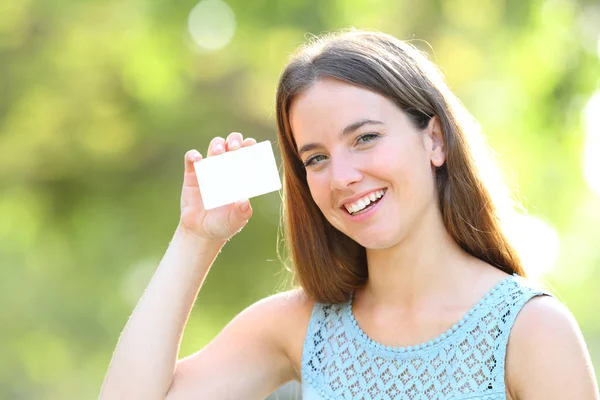 Mutlu kadın bir parkta boş bir kredi kartı gösteren — Stok fotoğraf