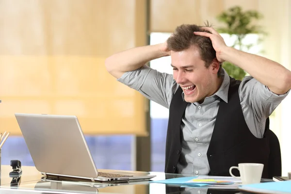 Возбужденный бизнесмен проверяет содержимое ноутбука в офисе — стоковое фото