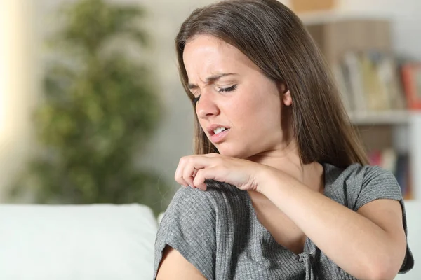 Mujer que sufre picazón rascarse el hombro —  Fotos de Stock