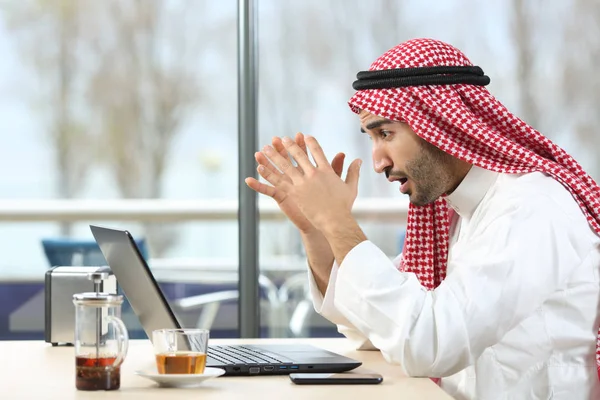 Σοκαρισμένος Άραβας άνθρωπος έλεγχος laptop σε ένα μπαρ — Φωτογραφία Αρχείου