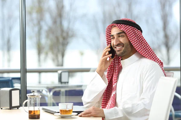 Счастливый араб разговаривает по телефону в кафе — стоковое фото