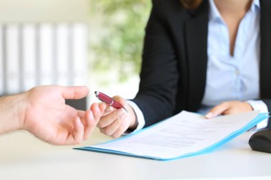 Satıcı bir sözleşme imzalamak için bir müşteriye kalem veren