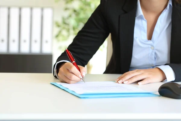 Businesswoman signing a contract on a desktop at office Stock Image