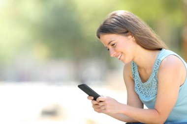 Mutlu kadın bir parkta telefon online içerik kontrol