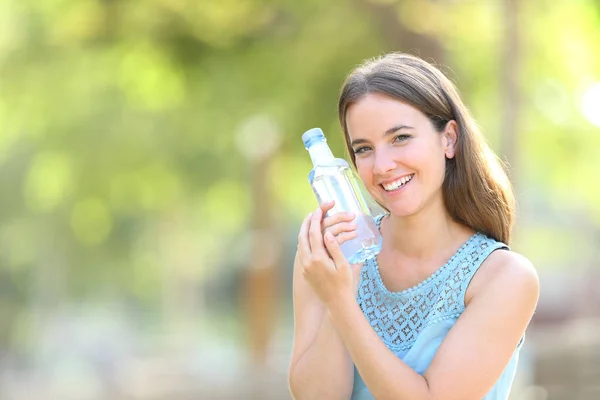 Kobieta kochająca plastikową butelkę wody na zielono — Zdjęcie stockowe