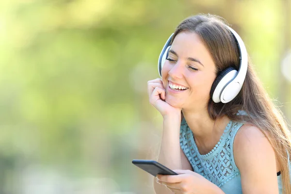 スマートフォンで音楽を聴いてリラックスする幸せな女の子 — ストック写真