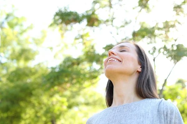 Gelukkige volwassen vrouw die frisse lucht ademt in een bos — Stockfoto