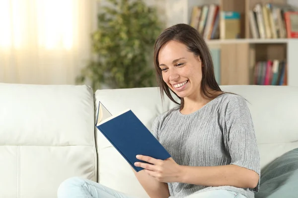 Femme heureuse à la maison lisant un livre de papier — Photo