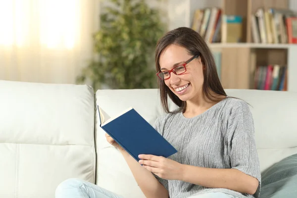 Wanita bahagia memakai kacamata di rumah membaca buku — Stok Foto