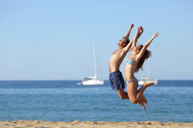 Heyecanlı çift tatil kutluyor sahilde atlama