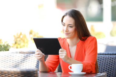 Ciddi kadın bir barda tablet online içerik izlerken