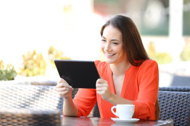 Mutlu kadın bir kafede tablet te video izliyor